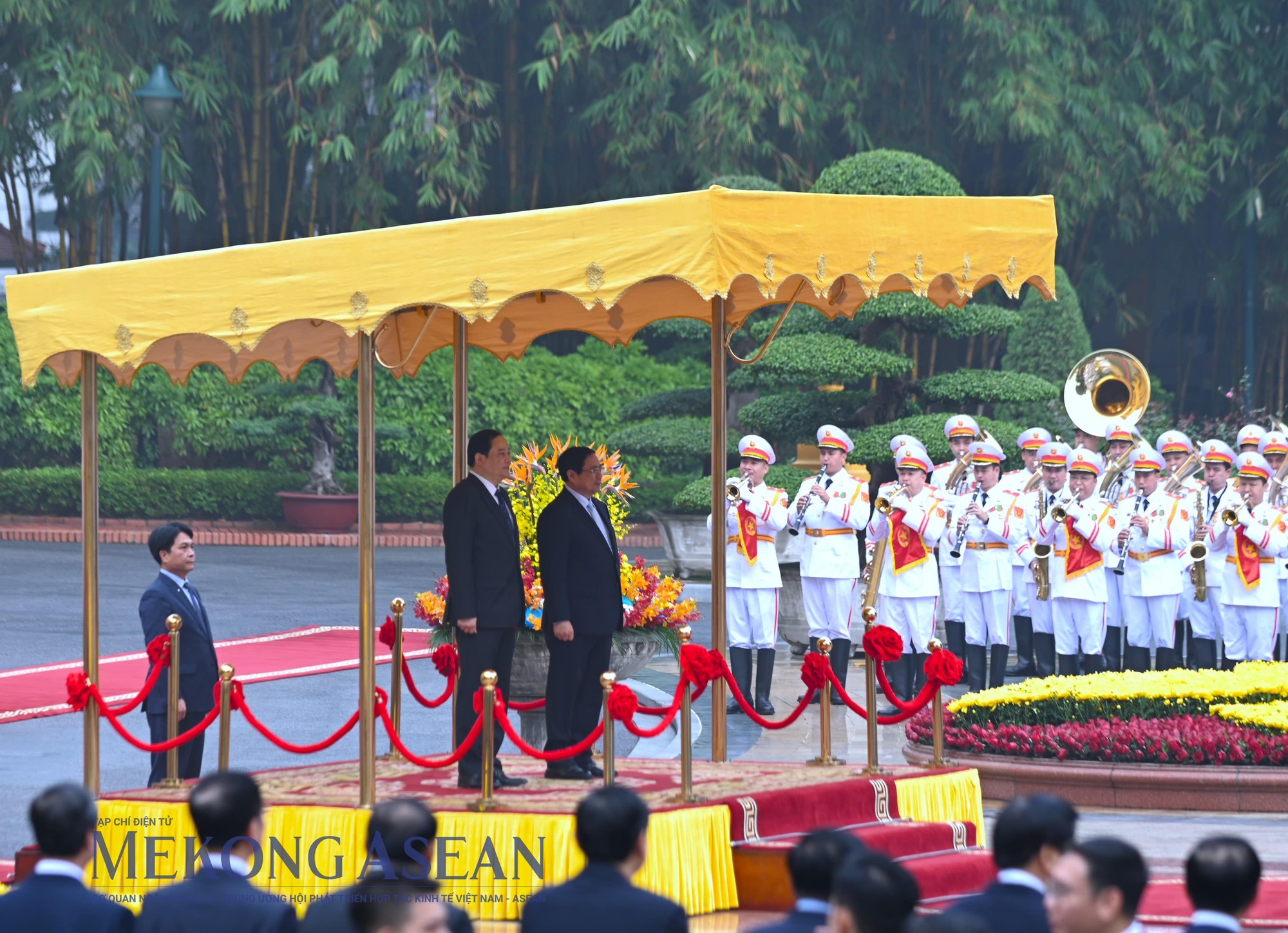 Thủ tướng Phạm Minh Chính và Thủ tướng Lào Sonexay Siphandone đứng trên bục danh dự, thực hiện nghi thức chào cờ của hai nước Lào và Việt Nam. Ảnh: Đỗ Thảo