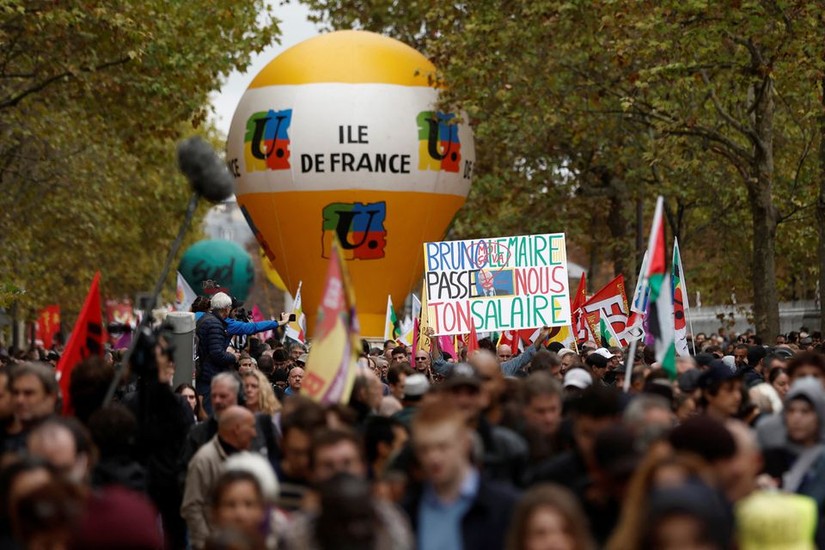 Những người biểu tình tại thủ đô Paris ngày 18/10. Tấm biển ghi "Bruno Le Maire, hãy trả lương cho chúng tôi". Ảnh: Reuters