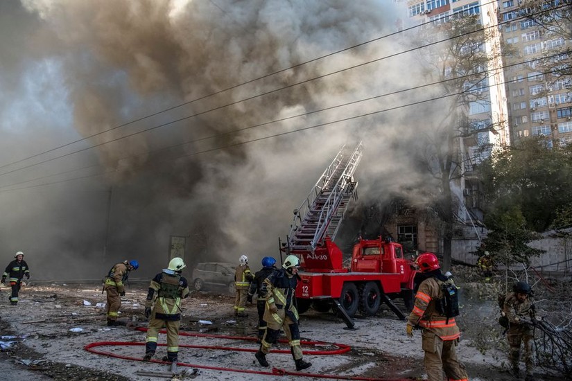 Lính cứu hỏa đang dập tắt đám cháy ở Kiev sau cuộc tập kích của UAV cảm tử, ngày 17/10. Ảnh: Reuters