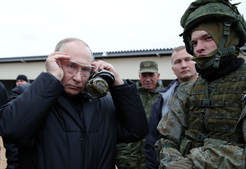 Tổng thống Putin đeo kính bảo hộ trước khi thử bắn súng. Ảnh: Sputnik