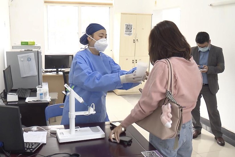 Nhân viên y tế hướng dẫn người dân tiếp nhận vaccine Covid-19 dạng hít. Ảnh: AP