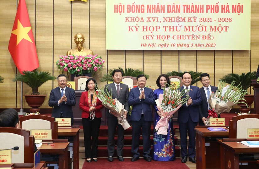 Lãnh đạo TP Hà Nội tặng hoa chúc mừng Tân Phó Chủ tịch UBND TP Hà Nội Vũ Thu Hà (áo dài xanh) và các Ủy viên UBND Thành phố. Ảnh: VGP
