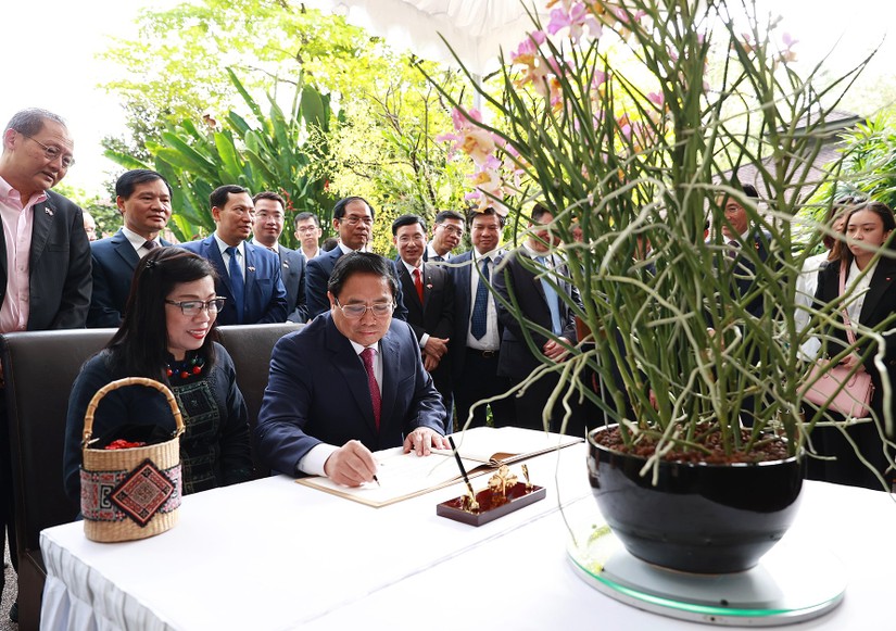 Thủ tướng Phạm Minh Chính ký sổ lưu niệm tại lễ đặt tên hoa lan ở Vườn Lan quốc gia Singapore. Ảnh: VGP