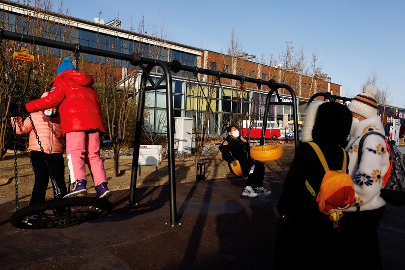 Trẻ em chơi xích đu tại một sân chơi ngoài trời ở Bắc Kinh, Trung Quốc, ngày 14/1. Ảnh: Reuters