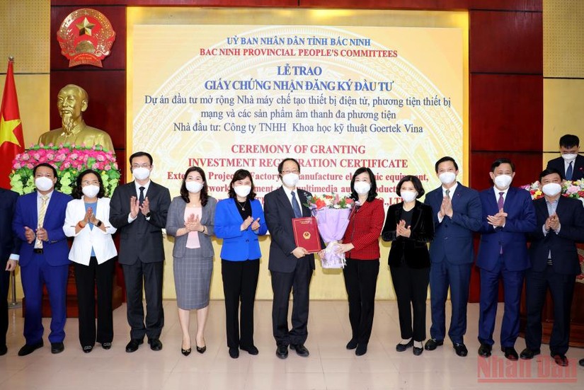 Lãnh đạo tỉnh Bắc Ninh tặng hoa chúc mừng Công ty Goertek Vina được trao giấy chứng nhận đầu tư mở rộng. Nguồn: Báo Nhân Dân.
