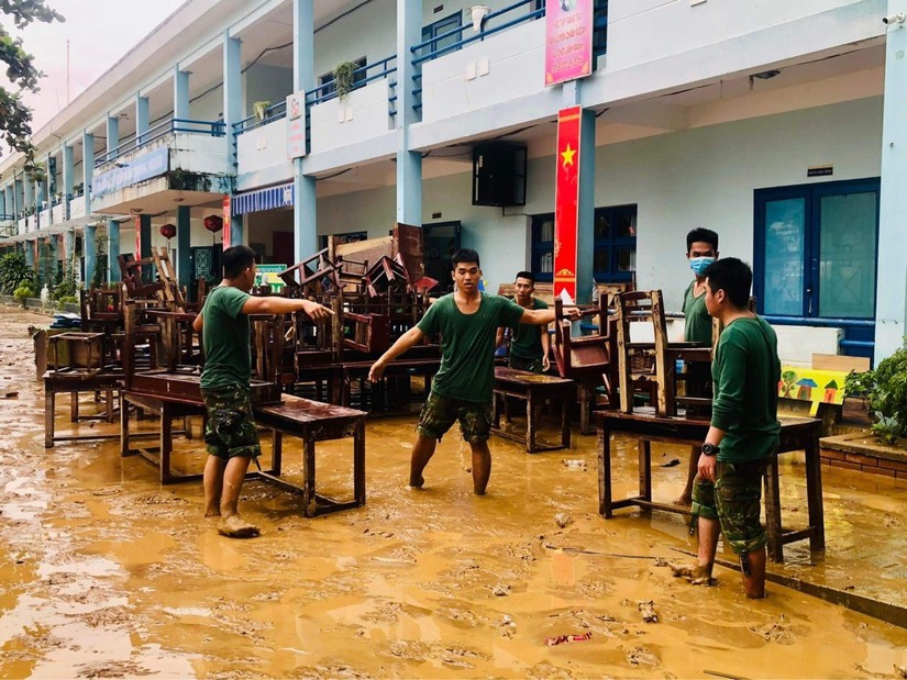 Lực lượng quân đội hỗ trợ dọn dẹp, khắc phục tại các trường ngập nặng. Ảnh: VGP