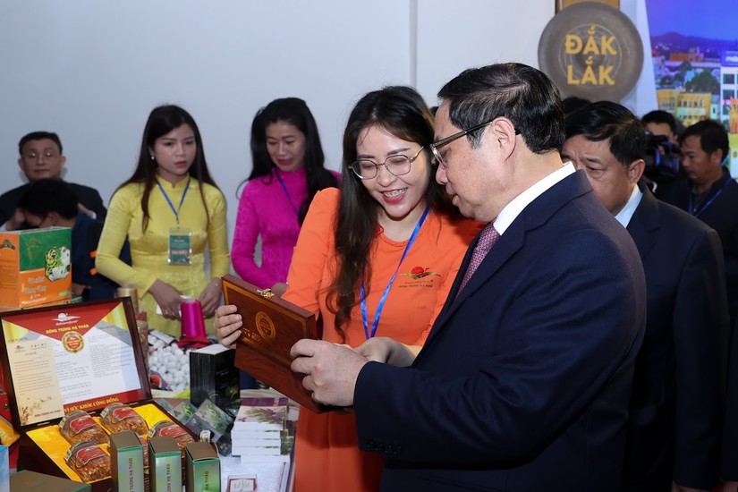 Thủ tướng Phạm Minh Chính nghe giới thiệu sản phẩm tại Triển lãm ảnh và gian hàng trưng bày nông sản Vùng Tây Nguyên. Ảnh: VGP