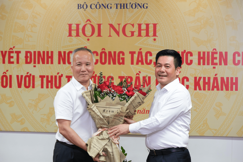 Bộ trưởng Công Thương Nguyễn Hồng Diên trao Quyết định nghỉ hưu và tặng hoa chúc mừng Thứ trưởng Trần Quốc Khánh. Ảnh: Bộ Công Thương