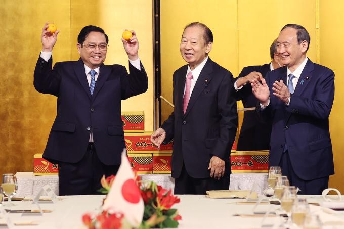 Thủ tướng Phạm Minh Chính dự lễ xuất hành quýt Unshu của Nhật sang Việt Nam trong cuộc gặp cựu thủ tướng Suga Yoshihide sáng 23/11 tại Tokyo. Ảnh: TTX