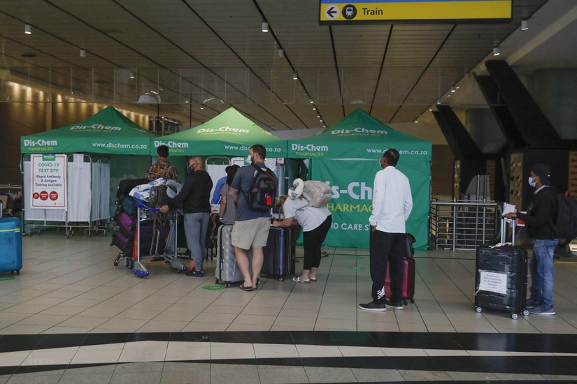 Hành khách xếp hàng chờ xét nghiệm Covid-19 tại sân bay quốc tế OR Tambo ở Johannesburg, Nam Phi, ngày 27/11/2021. Ảnh: AFP