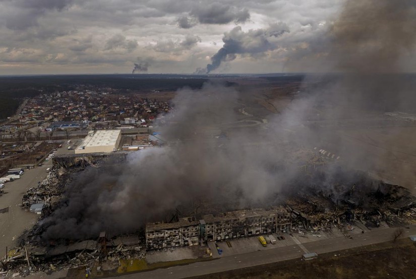 Một nhà máy và một cửa hàng đang bốc cháy sau khi bị bắn phá ở Irpin, ngoại ô Kiev, Ukraine, ngày 6/3. Ảnh: AP