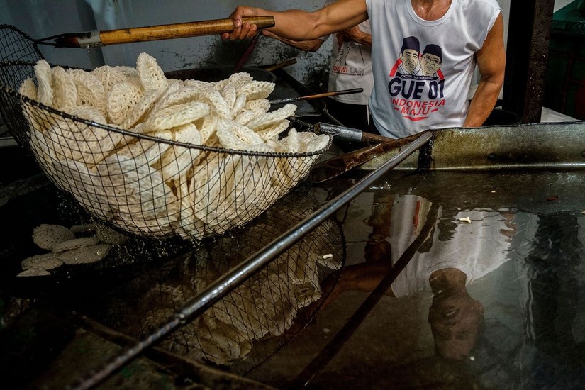 Đàn ông Indonesia chiên Krupuk, một loại bánh gạo được phục vụ trong hầu hết các bữa ăn, ở Jakarta. Ảnh: Getty Images