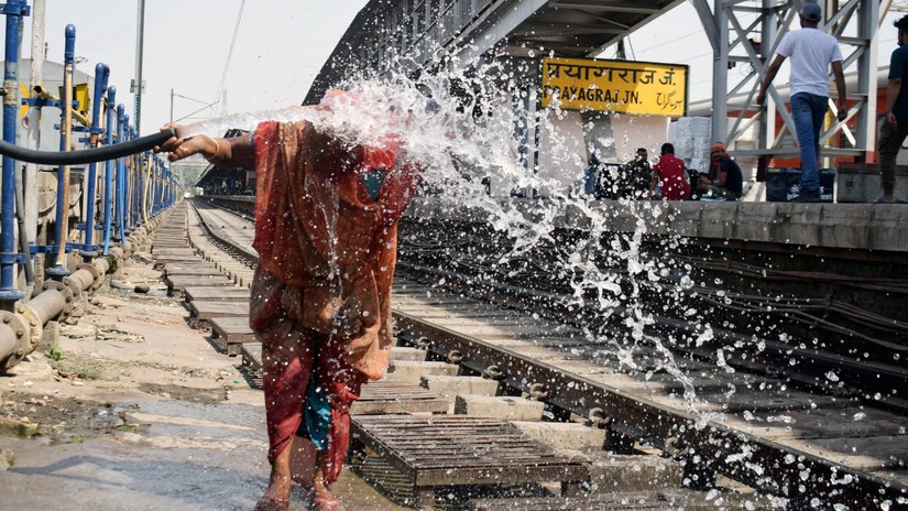 Một người phụ nữ tạt nước vào mặt trong một ngày hè tại nhà ga xe lửa Prayagraj, Ấn Độ. Ảnh: ANI Photo