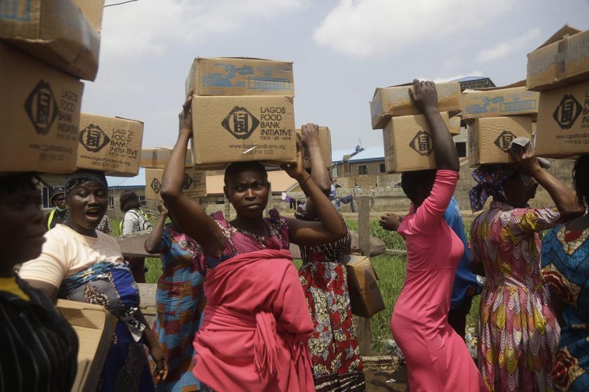 Cư dân của khu ổ chuột Oworonshoki nhận viện trợ thực phẩm ở Lagos, Nigeria. Ảnh: AP