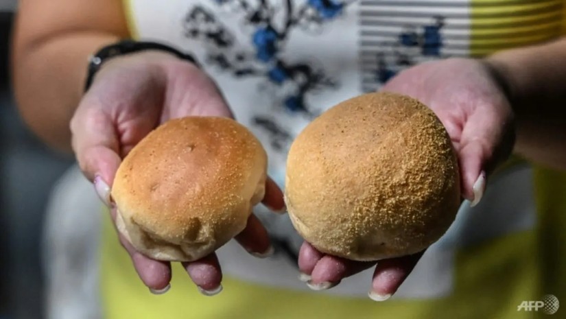 Thay vì tăng giá, chiếc bánh pandesal (trái) được làm nhỏ hơn so với bánh pandesal kích cỡ bình thường (phải). Ảnh: AFP
