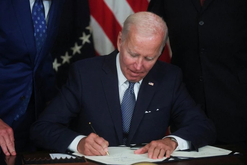 Tổng thống Mỹ Joe Biden đặt bút ký ban hành đạo luật Giảm lạm phát. Ảnh: Reuters