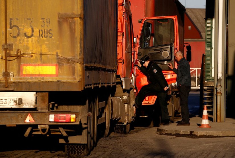Một người lính biên phòng kiểm tra chiếc xe tải tại khu vực Kybartai - biên giới giữa Nga và Lithuania. Ảnh: Reuters