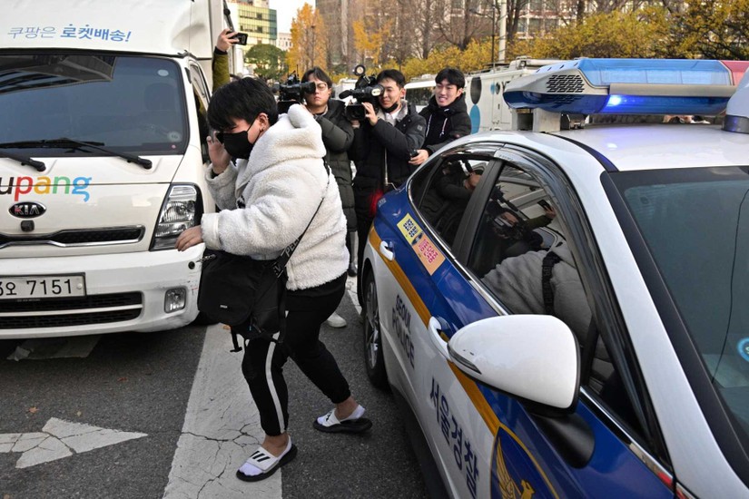 Một học sinh được cảnh sát hộ tống tới địa điểm thi đại học, ngày 17/11. Ảnh: AFP