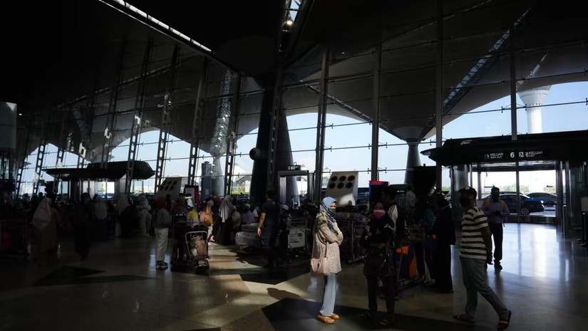Du khách xếp hàng tại quầy làm thủ tục ở Sân bay Quốc tế Kuala Lumpur, Sepang, Malaysia. Ảnh: AP