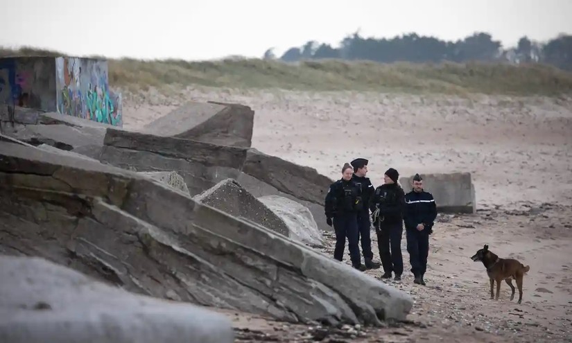Cảnh sát Pháp và chó nghiệp vụ tuần tra trên bãi biển Neville sur Mer, thuộc vùng Normandy. Ảnh: AFP