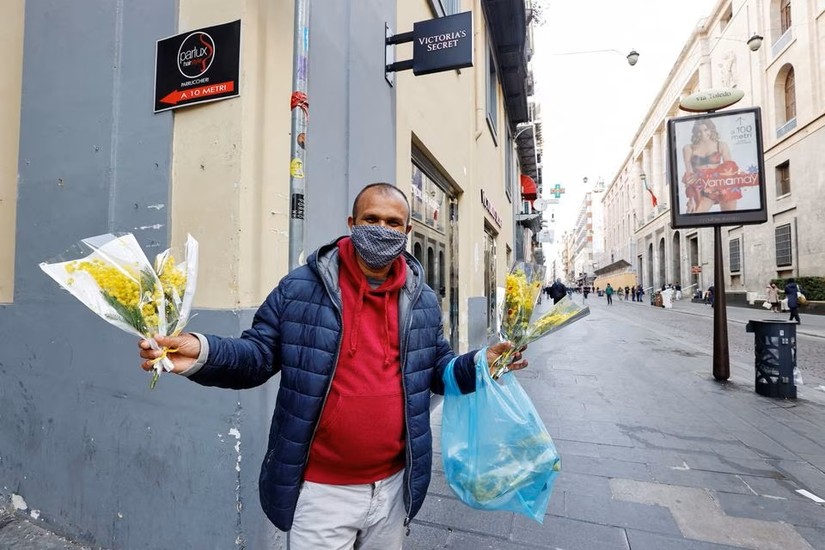 Một người bán hoa trên đường phố Naples, Italy, ngày 8/3/2021. Ảnh: Reuters