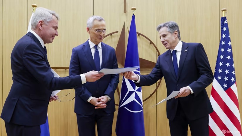 Ngoại trưởng Phần Lan Pekka Haavisto trao văn kiện gia nhập NATO cho Ngoại trưởng Mỹ Antony Blinken trước sự chứng kiến của Tổng thư ký Jens Stoltenberg. Ảnh: Reuters