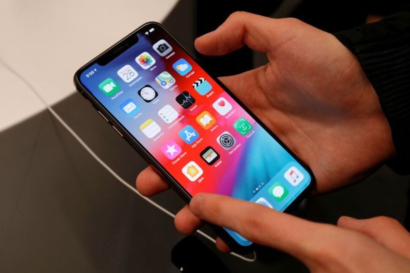 Một khách hàng kiểm tra điện thoại trong buổi ra mắt đợt giảm giá iPhone XS và XS Max tại cửa hàng Apple ở Moscow, Nga, năm 2018. Ảnh: Reuters