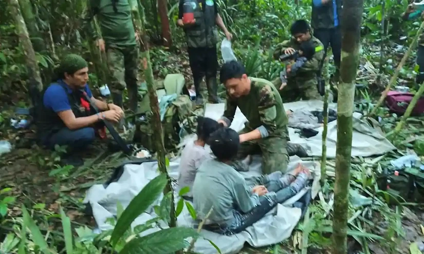 Các binh sĩ chăm sóc 4 đứa trẻ sau khi phát hiện chúng trong rừng. Ảnh: Văn phòng Tổng thống Colombia