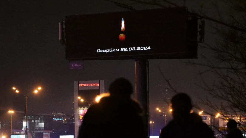 Ngọn nến tưởng niệm thắp trên màn hình quảng cáo gần tòa nhà Crocus City. Ảnh: RIA Novosti