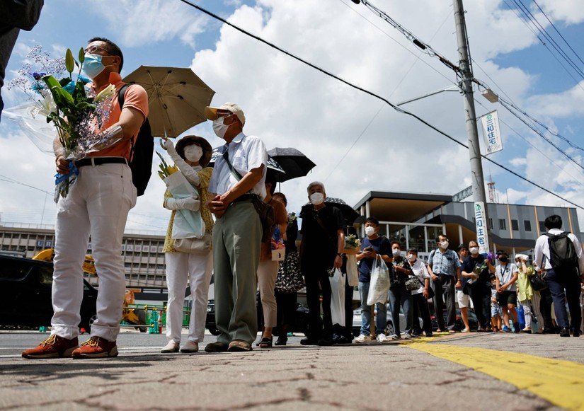 Người dân Nhật Bản xếp hàng cạnh nhà ga Yamato - Saidaiji tại Nara để đặt hoa tưởng niệm ông Abe. Ảnh: Reuters
