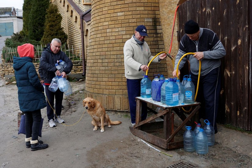 Người dân sinh sống gần sông Dnipro đổ đầy nước vào chai để sử dụng. Ảnh: Reuters 
