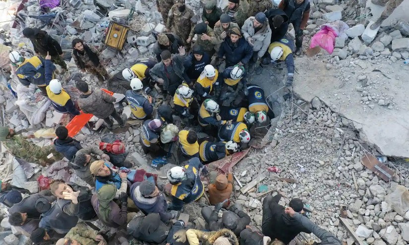 Lực lượng cứu hộ tìm kiếm thương vong và những người sống sót trong đống đổ nát của các tòa nhà tại ngôi làng Besnaya ở tỉnh Idlib phía tây bắc Syria. Ảnh: AFP