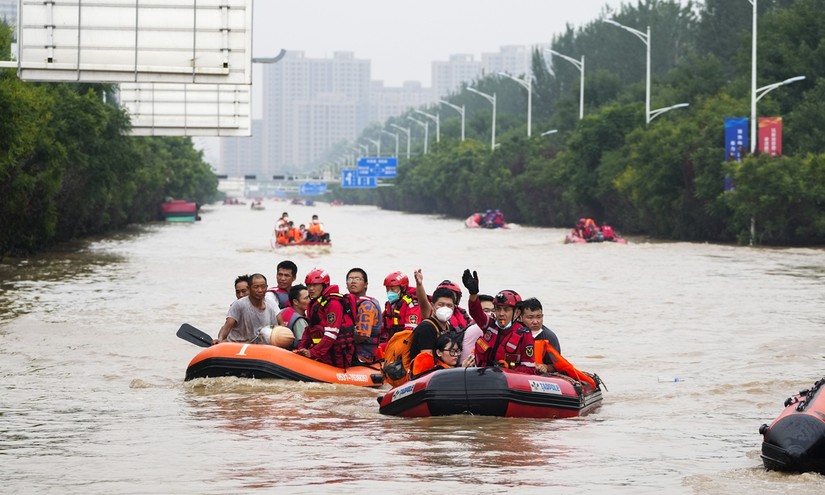 Người dân sơ tán trên thuyền cao su qua nước lũ ở Trác Châu, phía bắc tỉnh Hà Bắc của Trung Quốc. Ảnh: VCG