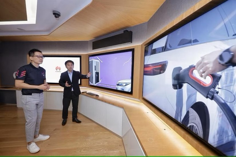 Giám đốc điều hành EV-electric Derek Tan (trái) và giám đốc điều hành Huawei Digital Power Singapore, Terry Gao, đang xem video thuyết trình về trạm sạc cực nhanh tại phòng thí nghiệm AI của Huawei ở Singapore ngày 18/3. Ảnh: Straits Times
